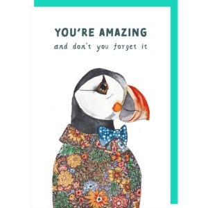 white birthday card with an illustration of a handsome puffin wearing a flowery shirt and a bow tie, caption reads ' You're amazing and don't you forget it'.